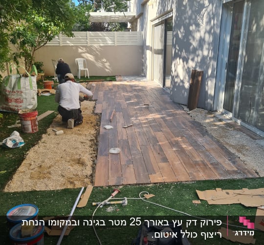 עובדים מתקינים רצפת עץ בחצר עם כלים וחומרים